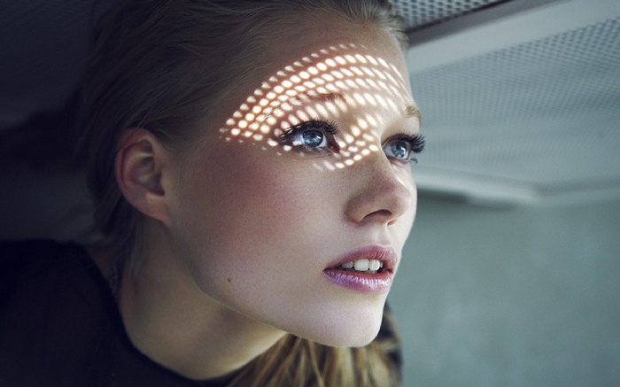 Woman with freckles and blue eyes looking up