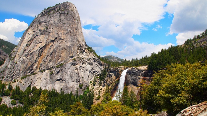 Granite dome and waterfall in a mountainous landscape