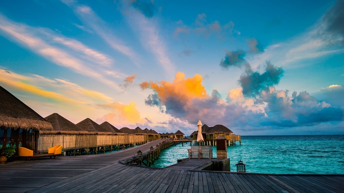 Sunset over a tropical resort with overwater bungalows