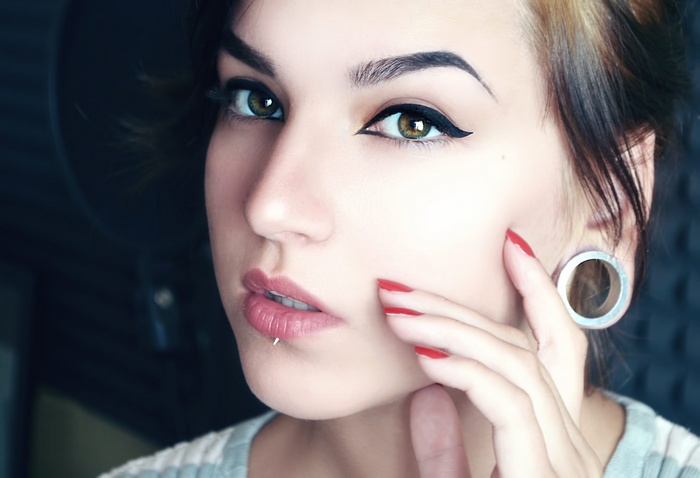 Woman with makeup and lip piercing