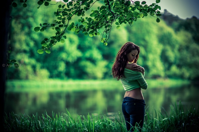 Woman in green top and jeans by the water