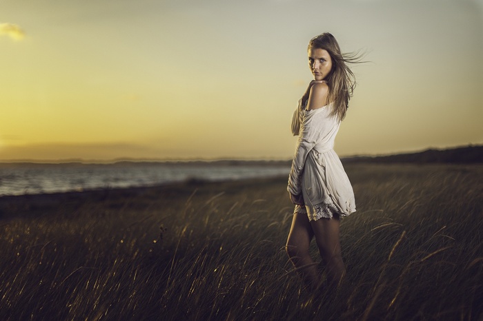 Woman in white dress at sunset on the beach