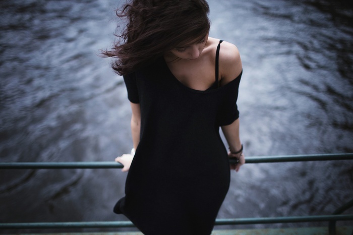 Woman in black dress by the water