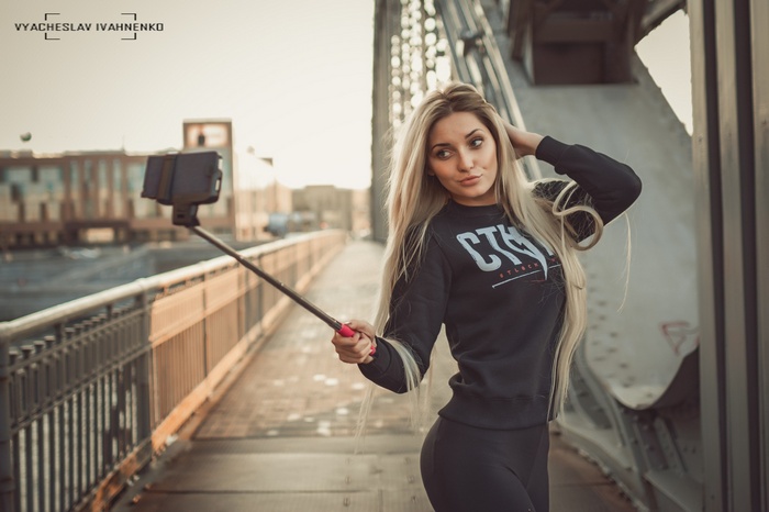 Woman taking a selfie on a bridge