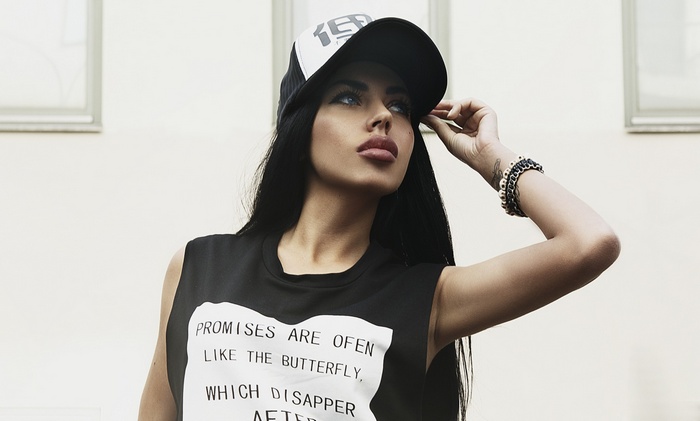 Woman wearing a black t-shirt and a baseball cap