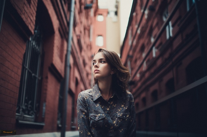 Portrait of a young woman in a city alley