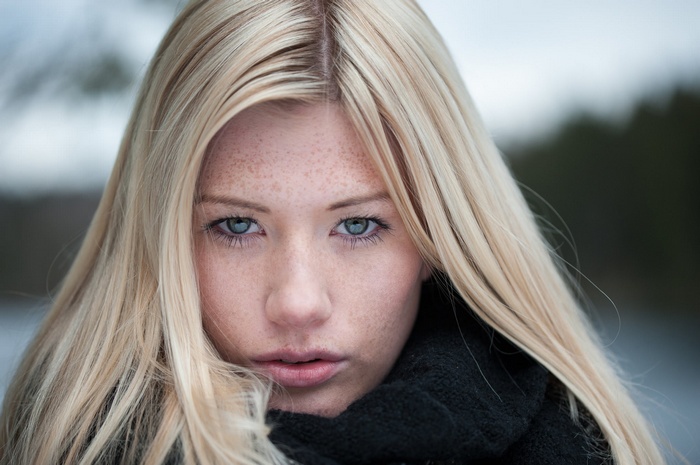 Portrait of a blonde woman with freckles and blue eyes