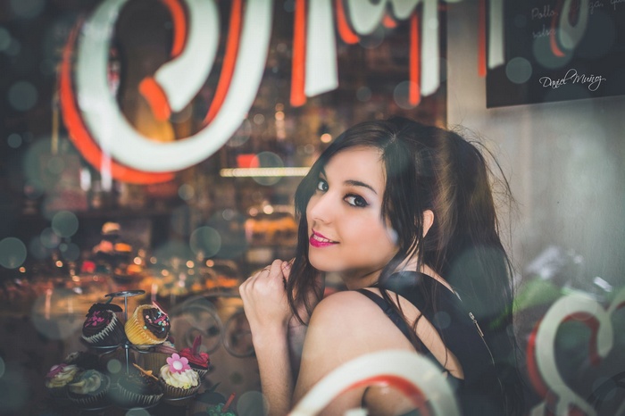 Woman smiling in front of a bakery window