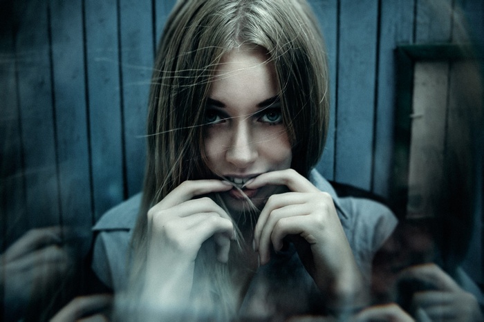 Woman with blonde hair biting her fingers
