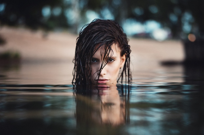 Woman with wet hair emerging from water