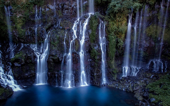 Waterfall cascading into a deep blue pool