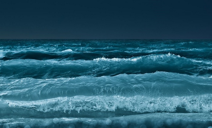 Ocean waves crashing under a dark sky
