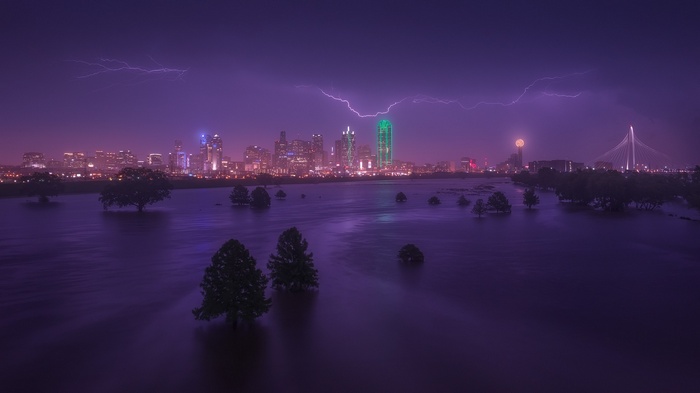 Dallas skyline during a lightning storm over flooded land