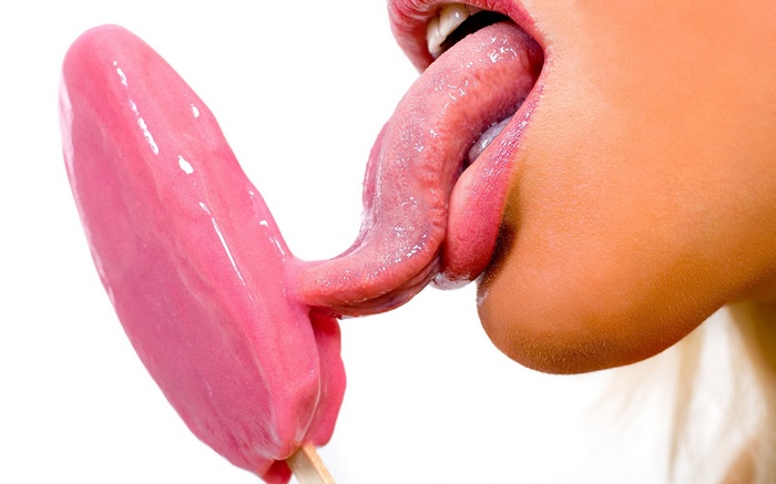 Woman licking a pink ice cream bar