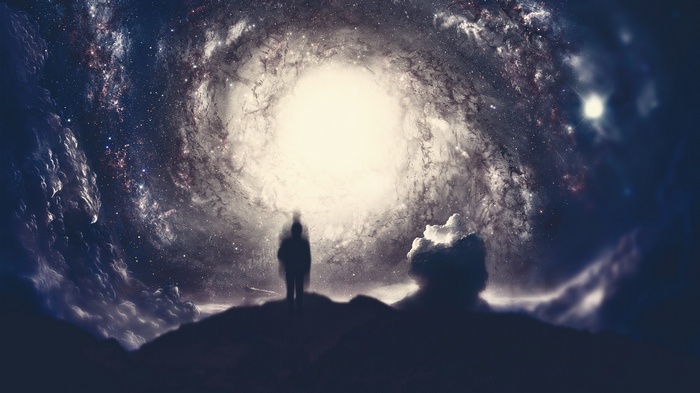 Silhouette of a person in front of a swirling galaxy