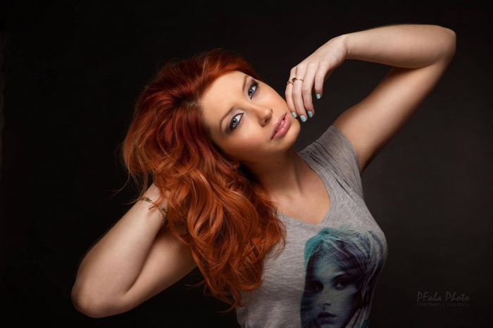 Redhead woman with long wavy hair posing