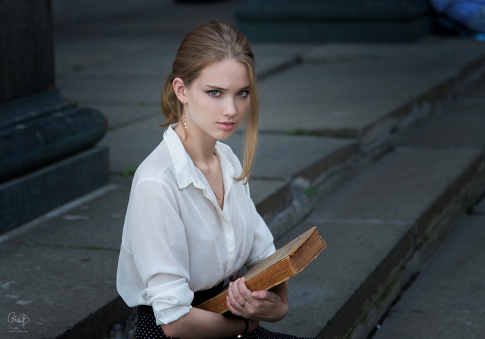 Woman with blonde hair holding a book