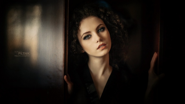 Woman with curly hair in dark setting