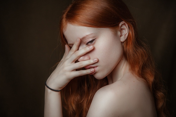 Redhead woman with hand covering face