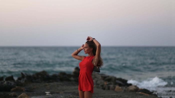 Woman in red dress by the sea