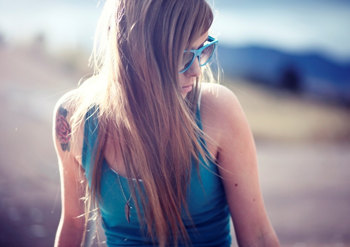 Woman with sunglasses and tattoo outdoors