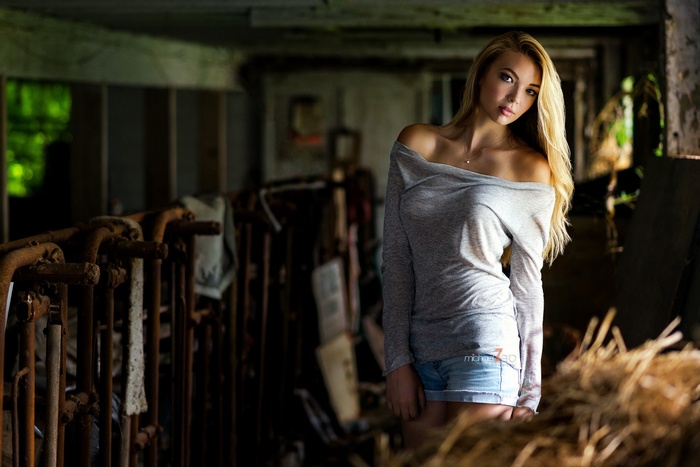 Blonde woman in jean shorts in a barn