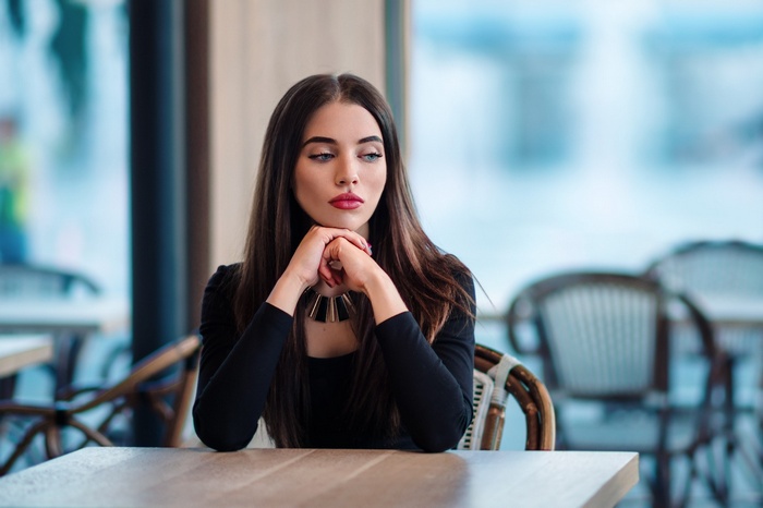 Woman with long brown hair sitting at a table