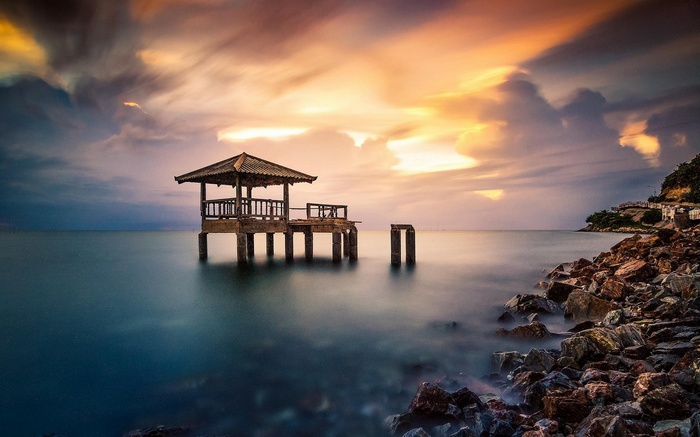 Abandoned dock on the coast of Thailand at sunset