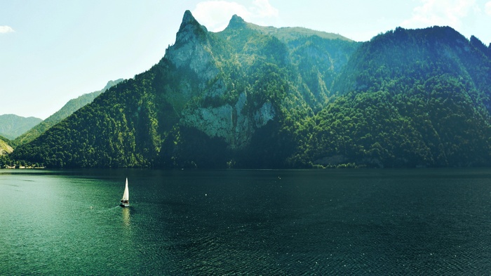 Sailboat on a lake with mountains and trees