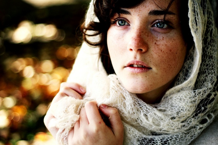 Woman with blue eyes and freckles wearing a scarf