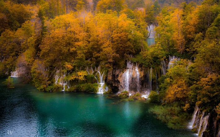 Autumn forest with waterfalls and a turquoise lake
