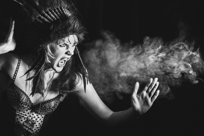 Woman in Native American Headdress Exhaling Smoke
