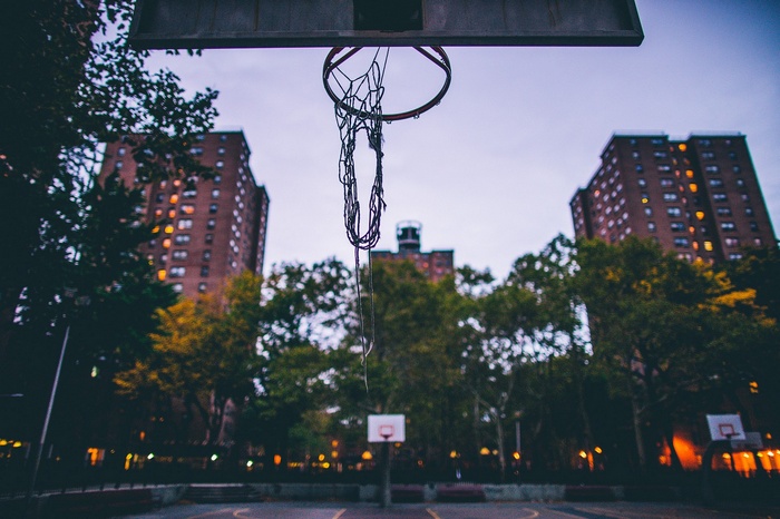 Basketball court with apartment buildings at dusk