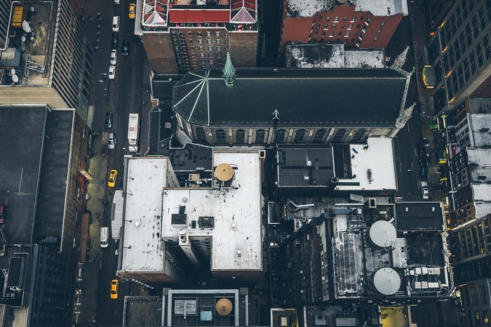Aerial view of a city street with buildings and a church