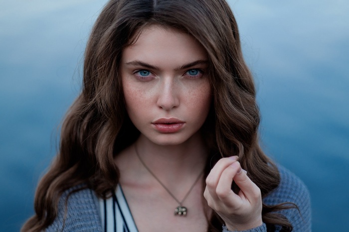 Portrait of a young woman with blue eyes and freckles