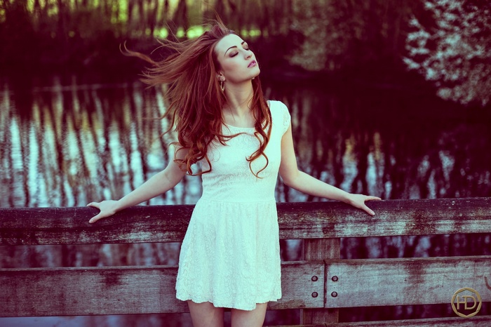 Woman in white dress on a wooden bridge