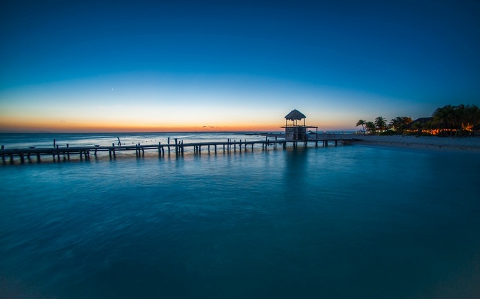 Tropical pier at sunset with palm trees in Mexico