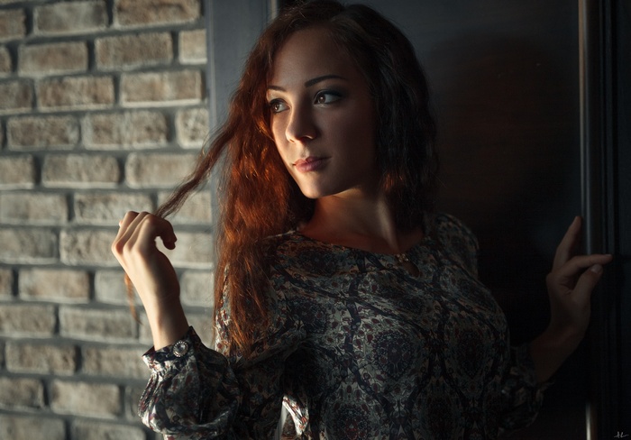 Woman with red hair touching her hair