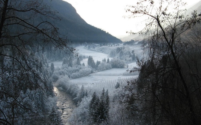 Snowy valley with a river and mountains