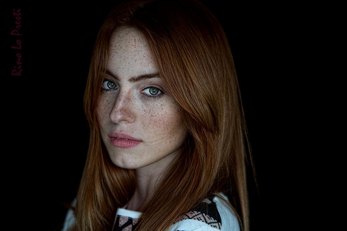 Portrait of a woman with auburn hair and freckles