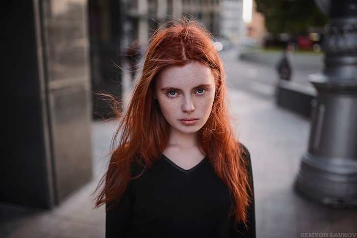 Portrait of a young woman with red hair and freckles