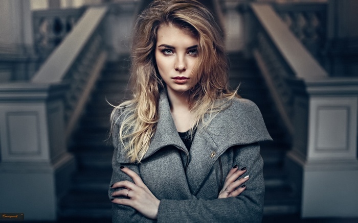 Woman with blonde hair wearing a grey coat