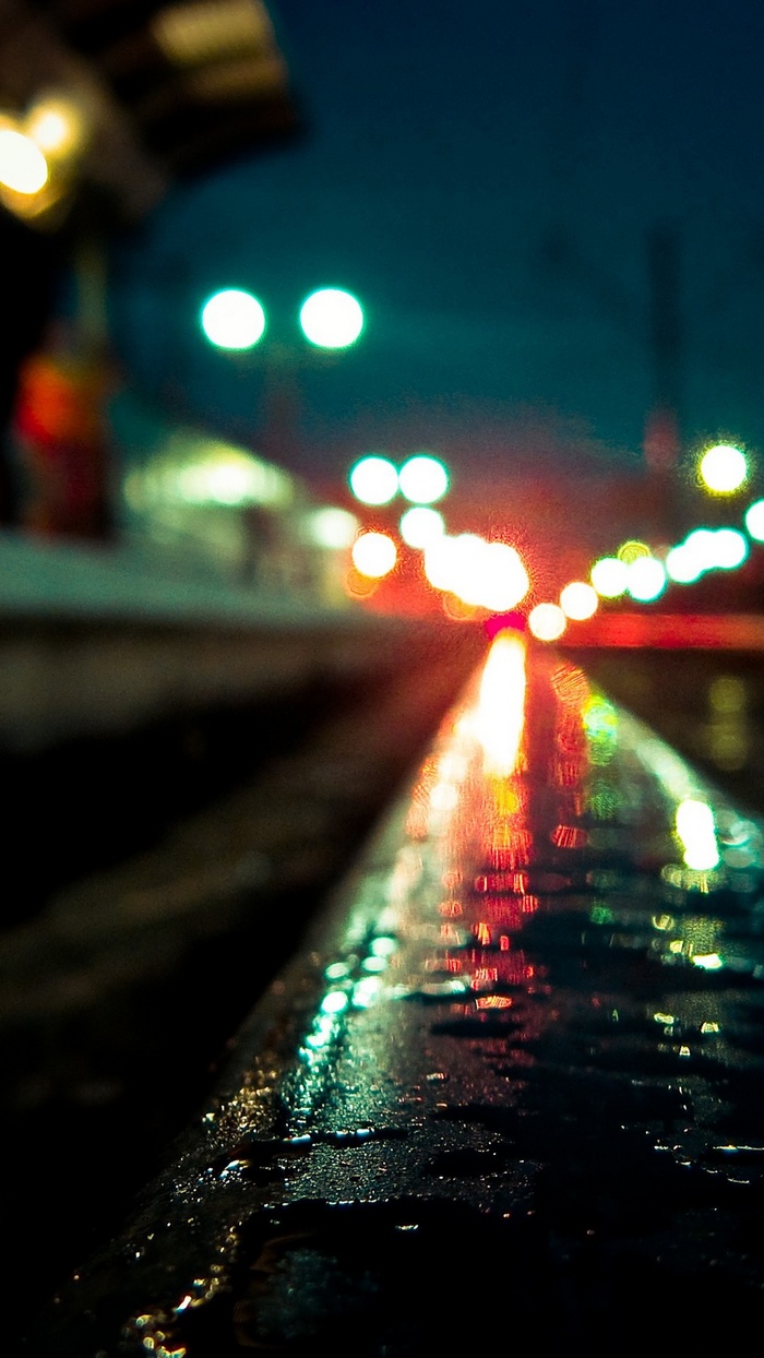 Bokeh lights on a wet rail yard at night
