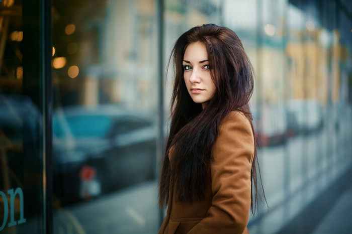 Woman with long brown hair wearing a brown coat