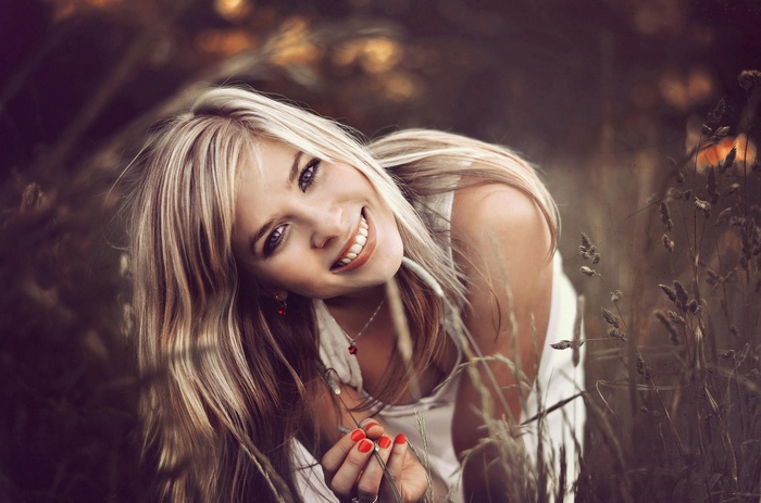 Woman with blonde hair smiling outdoors
