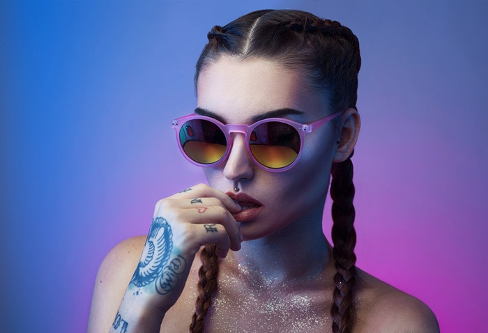 Woman with pink sunglasses and tattoos