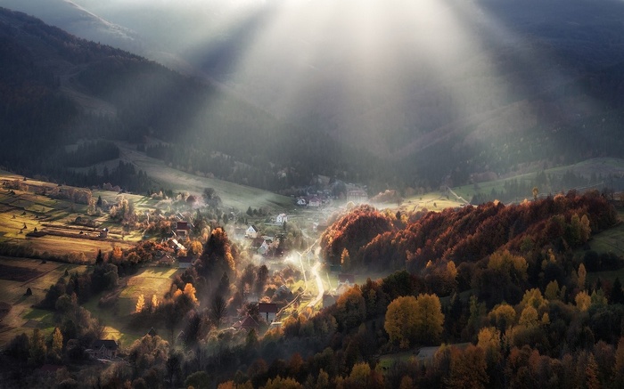 Sun rays over a mountain valley in fall