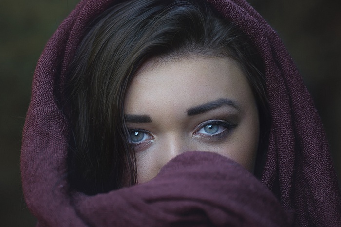 Woman with blue eyes covered by a maroon scarf