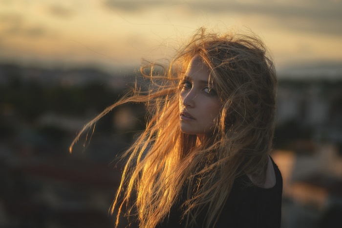 Woman with windblown blonde hair at sunset