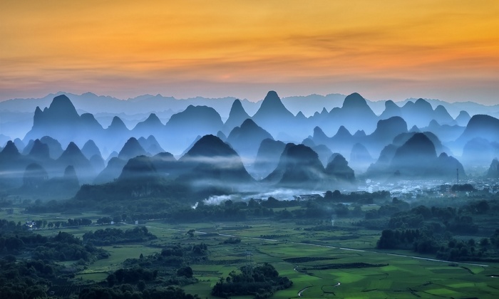 Misty mountains and fields in China at sunrise